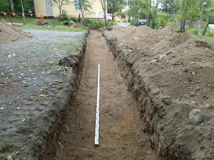 15 Koeoja 2 Pituus 25 m, syvyys 35-70 cm. Pysäköintialueen lounaispuolella. Koeojan luoteisosassa vaihtelevan paksuinen täyttökerros soraa, sen alta punaruskeaa hiekkaa ja sekoittunutta kerrosta.