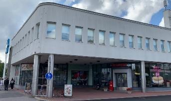 kerrostalossa on ulko-oven yläpuolella lippa. pylväiden koristamat portaalit.