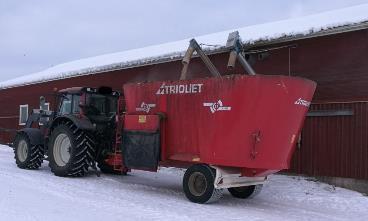 Tässä vaihtoehdossa tarvitaan usein traktorille ja apevaunulle varastotilat, joista kertyy kuluja. KUVA 12. Apevaunu ottamassa väkirehua (Rönkkö 2018-02-21.