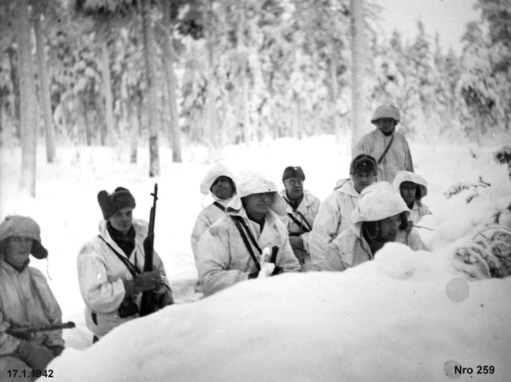 Malu Mussolinin edustajat viedään etummaisiin taisteluhautoihin, jotka kylläkin ovat vain lumeen kaivettuja.