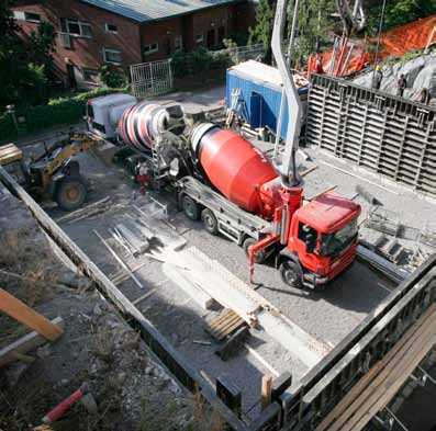 Kuva 17 Kellarin seinien betonivalu pyörintäsäiliöllä varustetulla betonipumppuautolla. Pyörintäsäiliöautolla betoni pystytään toimittamaan työmaalle tasalaatuisena.