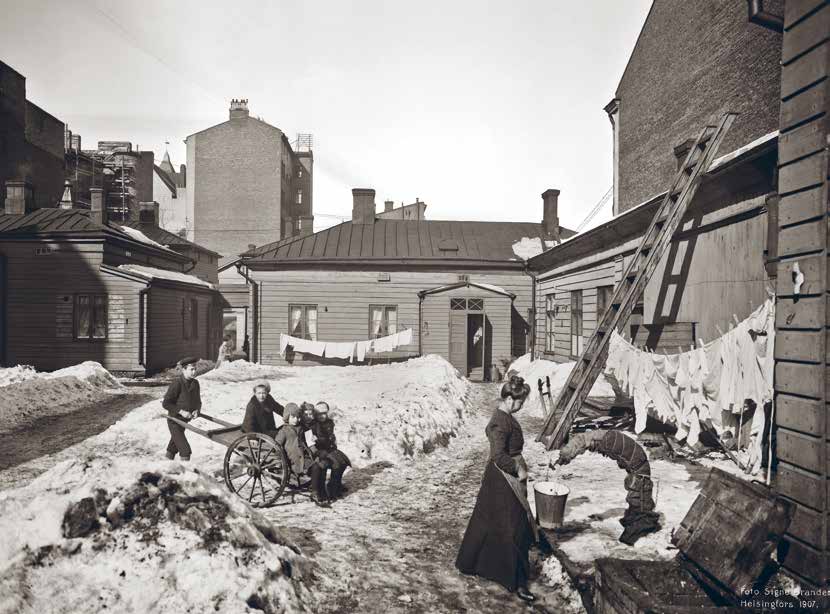 Signe Branderin vuonna 1907 ottamassa valokuvassa Selma Löfström täyttää ämpäriä vesipostista.