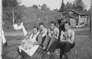 Alla vasemmalla Jussi lukemassa, oikealla Ritva, Ester, Jussi, harmonikka ja Lyydia. Huonosti käy myös sametinvalmistuksen.
