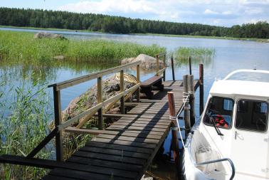 Uusi vene laiturissa ja merirosvoparrut. Vene sivulta Päivällä syötiin ja juotiin, illalla saunottiin ja poltettiin juhannuskokko.