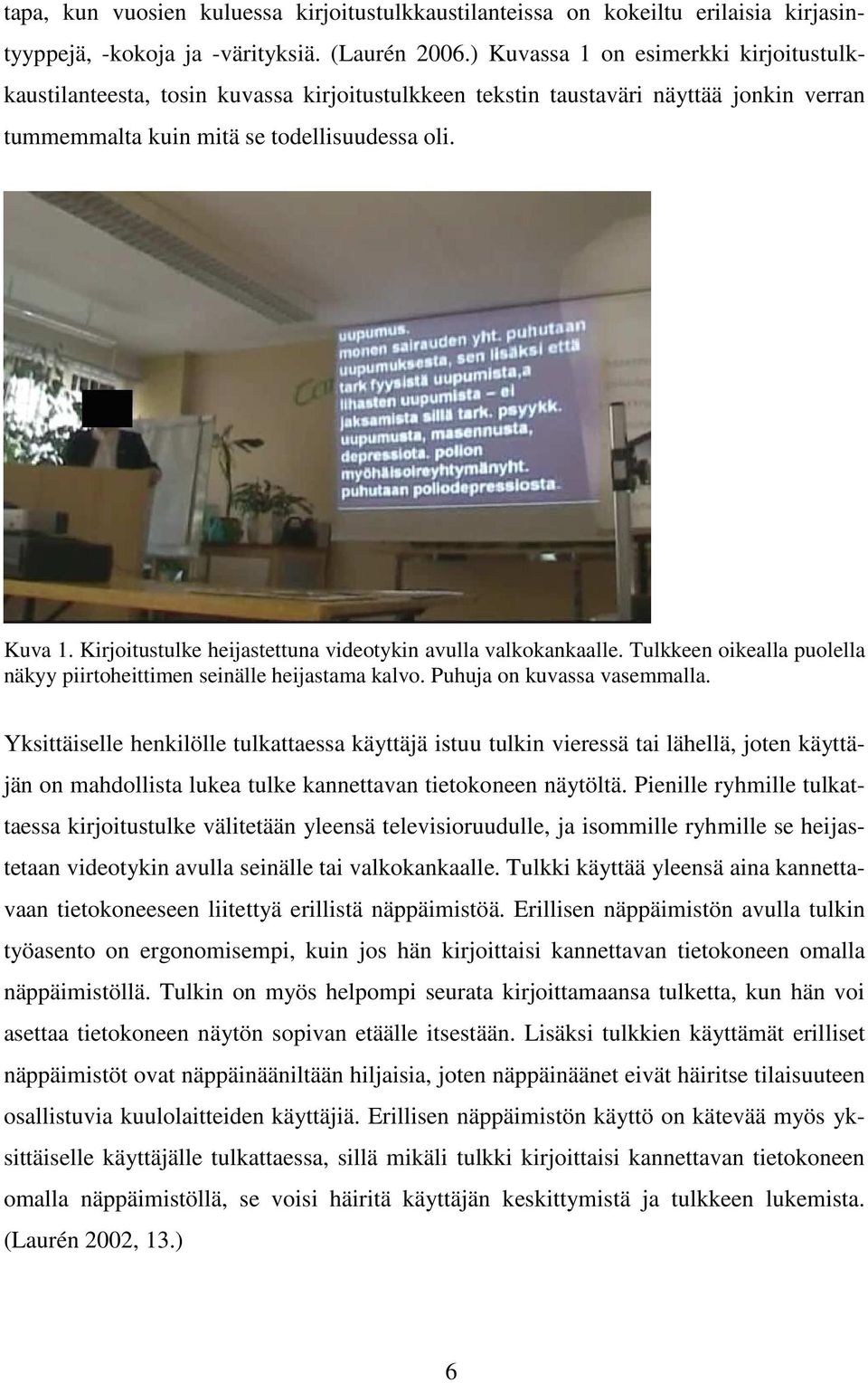 Kirjoitustulke heijastettuna videotykin avulla valkokankaalle. Tulkkeen oikealla puolella näkyy piirtoheittimen seinälle heijastama kalvo. Puhuja on kuvassa vasemmalla.