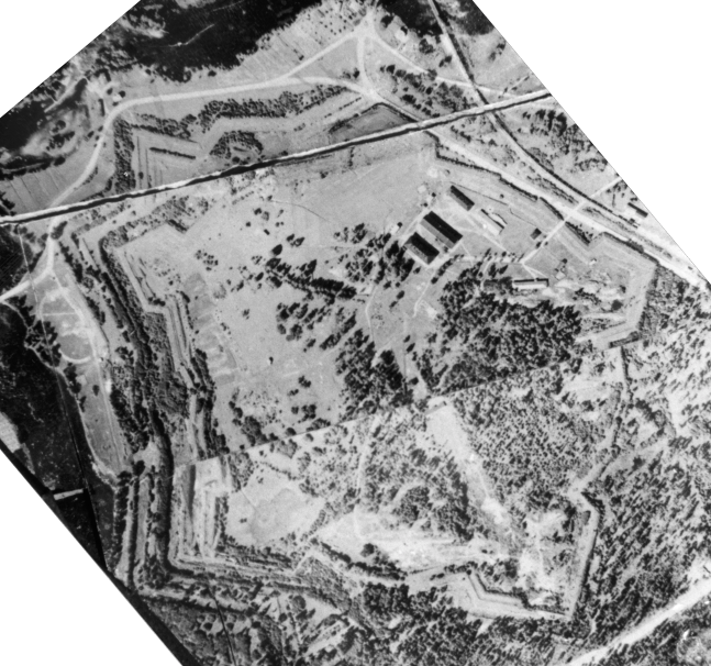 < Ilmakuva vuodelta 1936 näyttää tilanteen Kyminlinnassa pakolaisleirin viimeisimpinä vuosina.