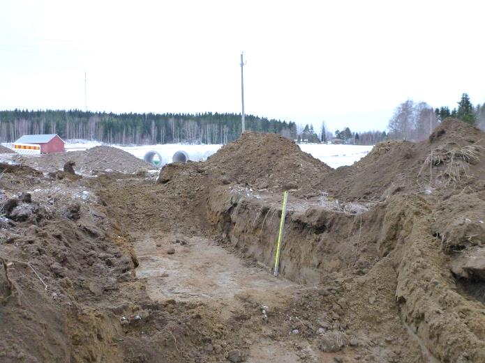 Teemu Tiainen tarkastelee kaivetun kaivannon 1 pohjaa, kaivannon itäpäässä.