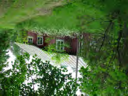 Pihapiiri, jonka päärakennus 1800-luvun puolivälistä. Pitkänurkkainen päärakennus. Puutarhainen pihapiiri.