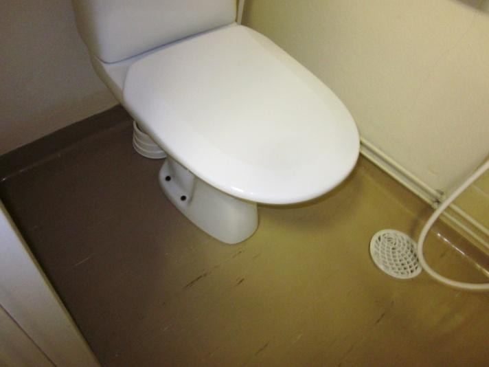WC-istuimet on kiinnitetty muovimaton läpi suoraan lattiaan, aiheuttaen kosteusvaurioriskin (kuva 25). Näillä kohdin havaittiin lattian pintakosteuksissa poikkeamia.