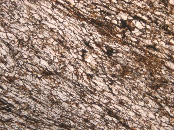 Magnesiumkarbonatiittia leikkaa nuorempi karbonatiittijuoni ja sitä breksioivat tektoniset hiertopinnat.