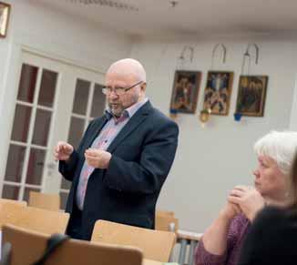 Pekka Soikkeli kysyy paastoruuista. Raija Pääskyvuori seuraa vieressä. Okko Balagurin opettaa katekumeeneja kolmatta vuotta Itä-Helsingissä. misesta kertovaa monistetta.