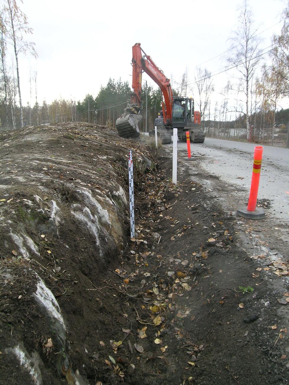 kalliopaljastuman (ks. luku 5.7.2.) luona sijainneelta räjäytystyömaalta. Perattuna noin metrin levyisen ja noin 40 cm syvyisen ojaosuuden seinämissä havaittiin vain puhtaan oloista harmaata savea.