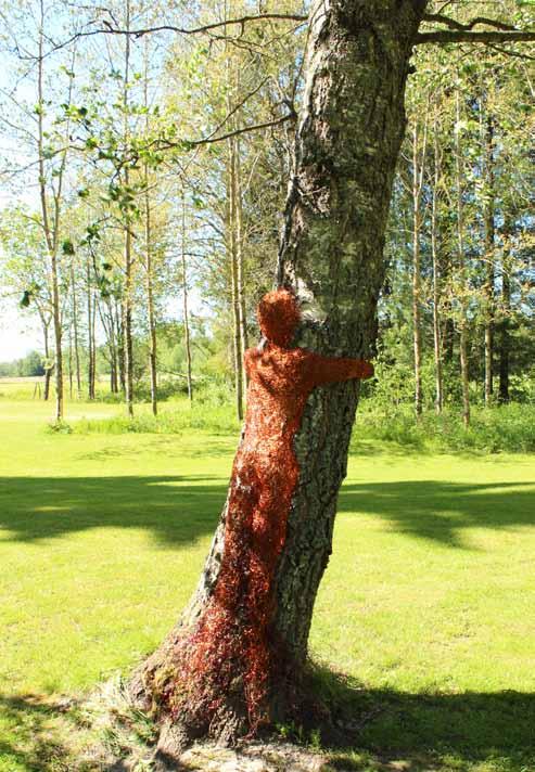 Mari Syrén-Fawaz Halaus on kuparilangasta punottu veistos suuren puun rungolla.
