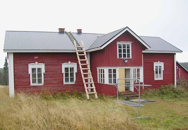 Kuva 112. Kelan tila. LKYT 2004. Toinen asuinrakennuksista on punainen hirsirakennus, joka lepää osittain luonnonkivipohjan päällä ja osittain luonnonkivipilareiden päällä. Kuisti on pystylaudoitettu.