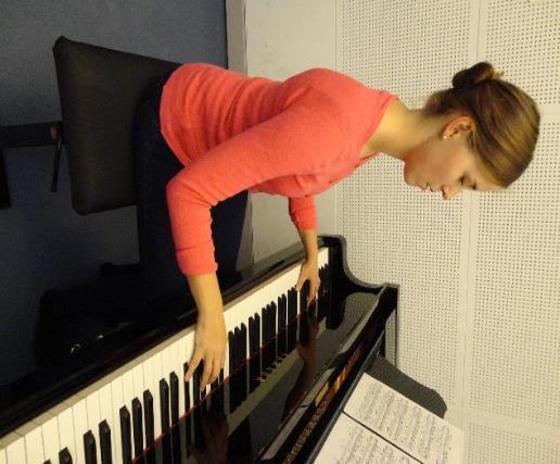voimalla. Puristava jännitys näkyy koko pianistin kehossa etukumarana asentona.