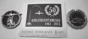 Kuva 10 Ilmatorjuntamuseon 50-vuotisjuhlapostimerkki. Kuvassa vasemmalla on Talvisodan ilmatorjunnan rintamerkki. Siinä näkyy sama kaksimoottorinen pommikone, kuin museonkin merkissä.