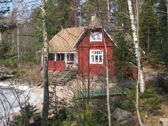 Jyhkeä hirsinen jugend-huvila sijaitsee kohti rantaa viettävällä