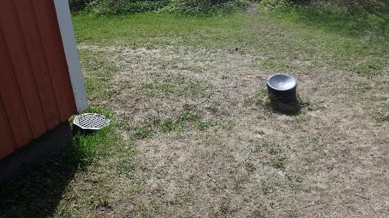 Kattosadevedet on ohjattu rännikouruilla sekä syöksyputkilla sadevesikaivoihin ja osin rakennuksen vierelle. Kuva 1. Maanpinta on tasainen. Kattosadevedet on johdettu sadevesikaivoon.