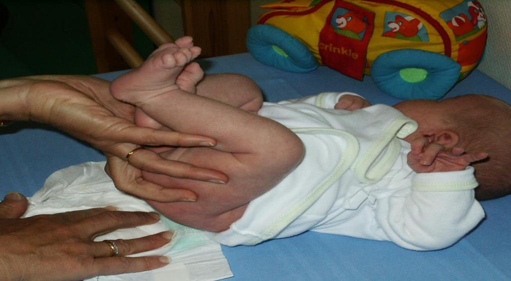 Vaippaa vaihtaessasi ohjaa vauvan jalat koukkuun: Joko: koukistamalla