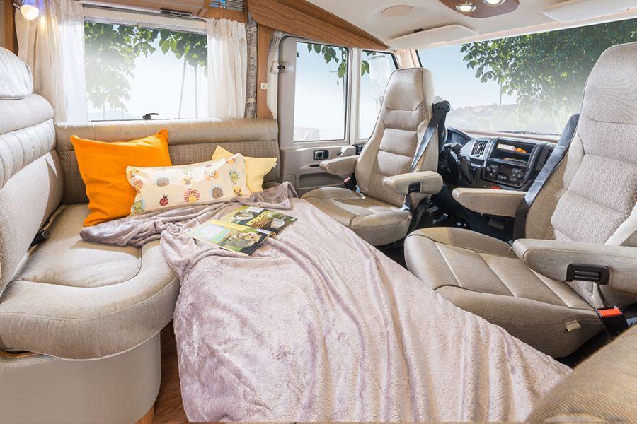 Yksi nukkumapaikka lisää Valinnaisesti voidaan lisäpehmusteosan, sohvan ja alaslaskettavan pöydän avulla muodostaa yksi nukkumapaikka lisää Hymermobil PremiumLinen malleissa.