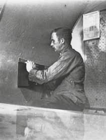 Kuvassa ltn Thorvard Livendhal. Hän työskenteli ilmavalvontakeskuksen tasolla ja vastasi ilmasuojeluhälytysten antamisesta. Veivaamalla kuvassa näkyvän laatikon kampea annettiin hälytys mm.