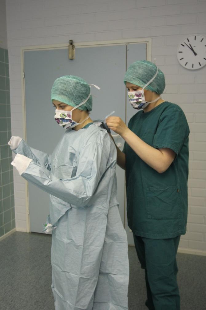 5.3 Steriili leikkaustakki ja sen pukeminen 21 Steriilin leikkaustakin tarkoituksena on ehkäistä hoitohenkilökunnan iholla olevien mikrobien pääseminen leikkausalueelle ja suojata hoitohenkilökuntaa