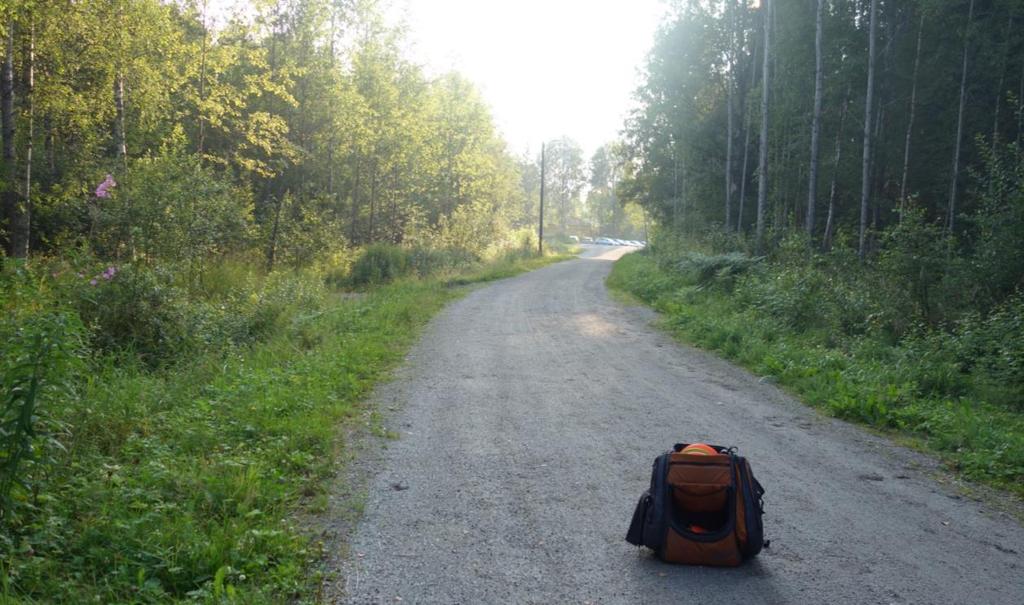 Väylä 17 - Varo autoja! Radan puttikoriin pelattava ulkoilureittiä kulkeva määrämittainen väylä. Korin takana OB linja vajaan 10 metrin päässä.