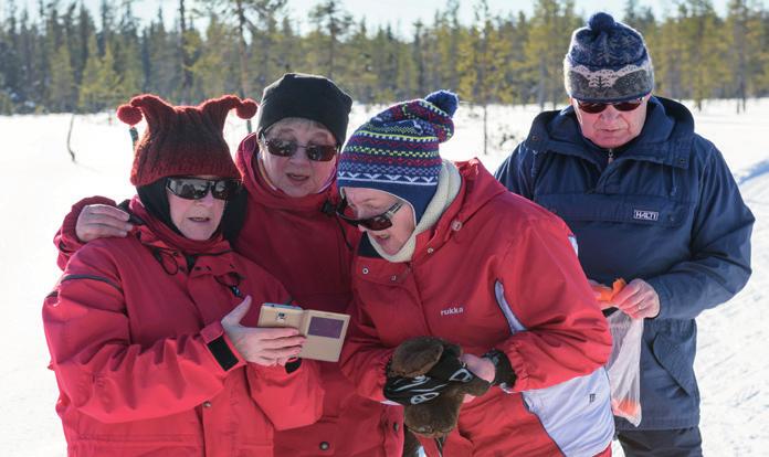 Kuva: Paavo Jaakkola Aada laskee mäkeä hiihtokoulussa, Muumipappa seuraa.