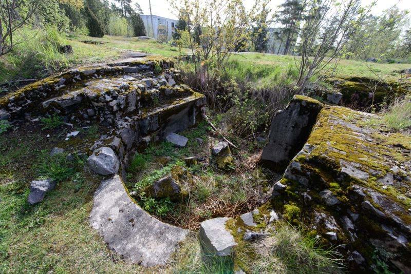 18 Konekivääriasema, jonka katto on räjäytetty. Asema on vanhempaa mallia, joka on varustettu kaarevalla etuseinällä. Rakennusmateriaaleina on käytetty muurattuja kiviä ja betonia.