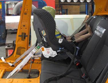 Kuva 6: Britax Hi-Way II kiinnitettynä auton koriin Jotta istuimen omia vöitä voisi säätää lapsen koon mukaan, on vyöt pujoteltava ensin ulos ja sitten taas takaisin.