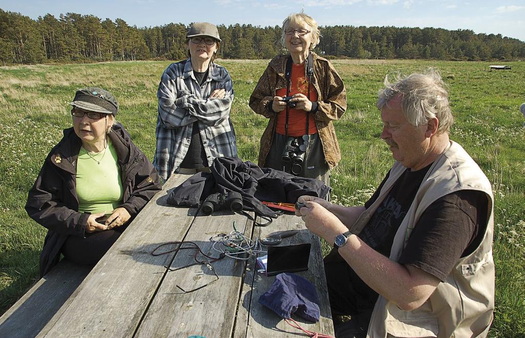 Tutkimus Arto Kalliola esittelee rengastustoimintaa Jurmossa vieraileville lintuharrastajille. Ringing demonstration at Jurmo B.O. Meri Öhman nätys.