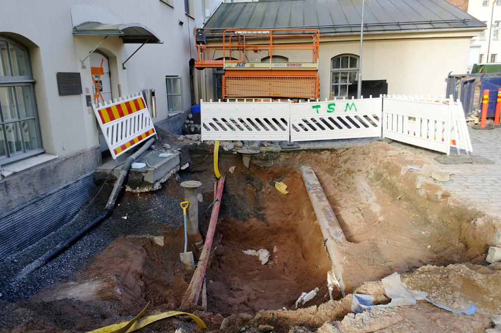 Kuva 3. Kaukokylmäkaivannon uuden linjauksen kohdalla maaperä oli täynnä kunnallistekniikkaa: oikealla on kaksi vanhaa kaukolämpöputkea ja keskellä kulkee sadevesiviemärien putkia.