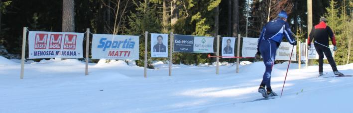 Siirrettävä mainostaulu sijaitsee Hakkarissa tykkilumiladun lipunmyynnin yhteydessä ja