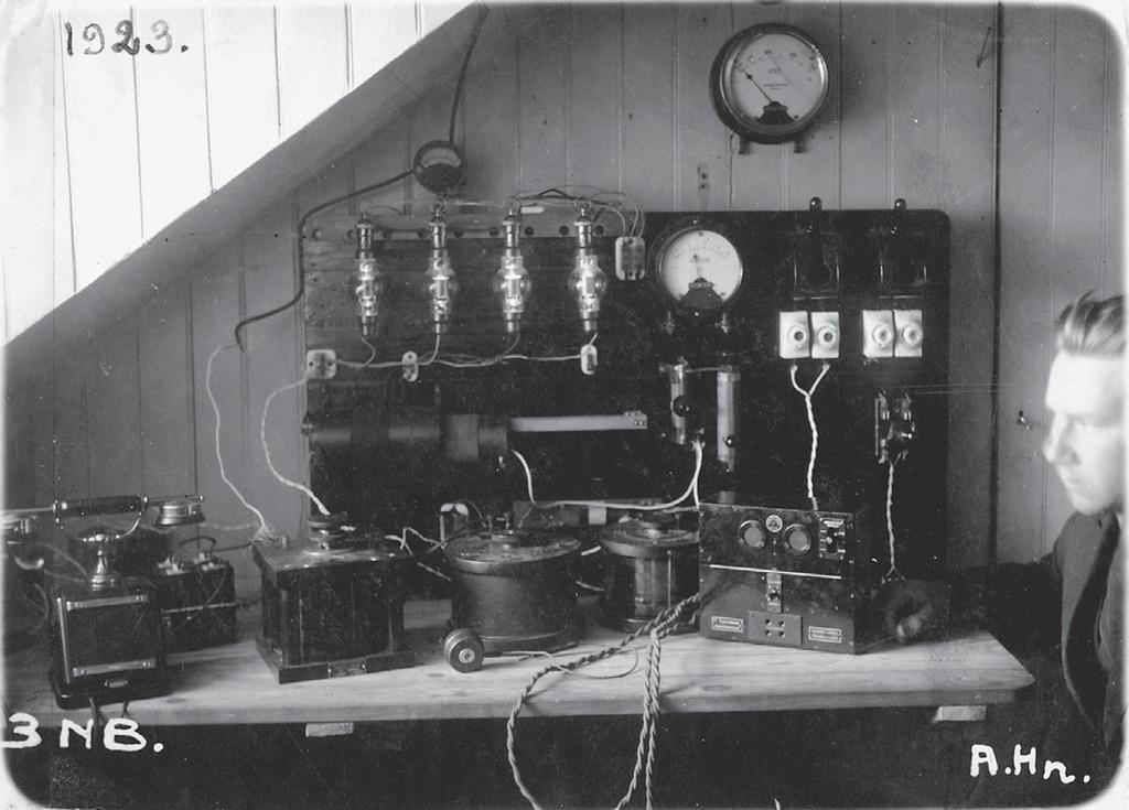 Suomen ensimmäinen yleisradiolähetin, asema 3 NB ja aseman konstruktööri Arvi Hauvonen syksyllä 1923. Lähde: Arvi Hauvonen, Lahden kaupunginmuseon kuva-arkisto. pinnasta.