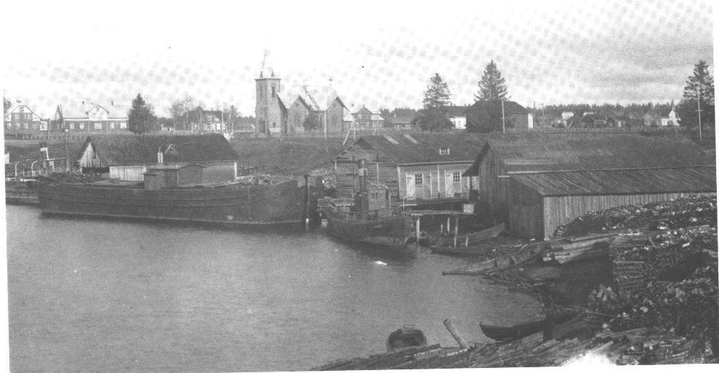 KUVA: TULEMAN SATAMA 1920-LUVULLA. TAUSTALLA EVANKELIS-LUTERILAINEN KIRKKO. KUVA TEOKSESTA MEIJÄN SALMI KUVINA.