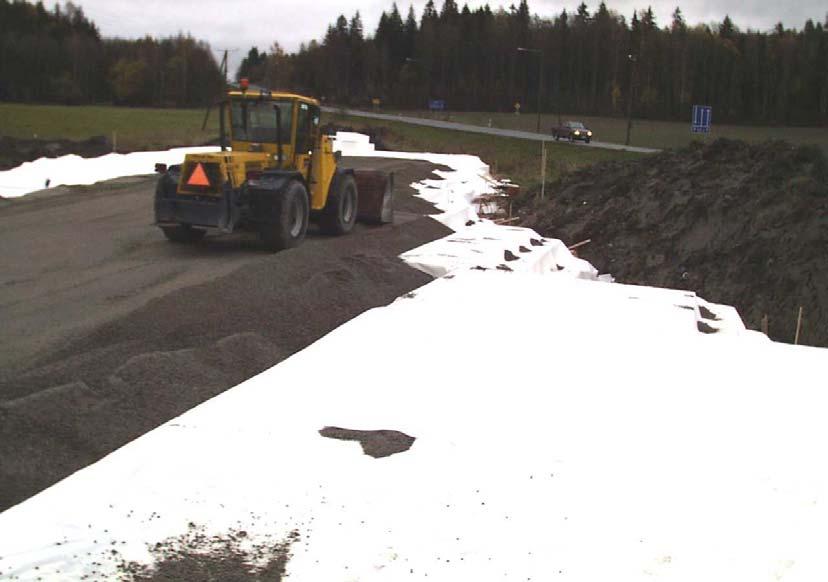 13 Kuva 12. Suojakerroksen levitystä. Jakava kerros, jonka paksuus oli 400 mm, rakennettiin yhtenä kerroksena, ja se tiivistettiin vasta keväällä 2002.