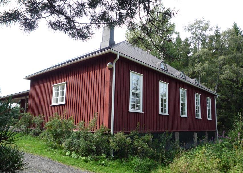 Kaakon puoleiseen julkisivuun on jälkikäteen rakennettu mutkaisten puunrunkojen varassa lepäävä katos.