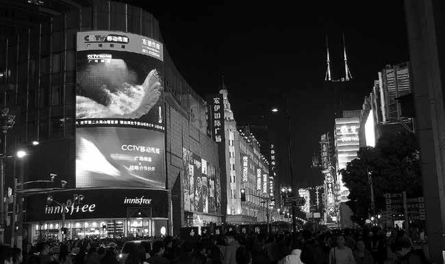 LAURI NIEMI, Helsinki KIINA-SEIKKAILUNI EKSYKSISTÄ ERÄMETSÄLLE Kiinan valtiollisen CCTV:n screeni Shanghain suurimmalla ostoskadulla Nanjing Roadilla.