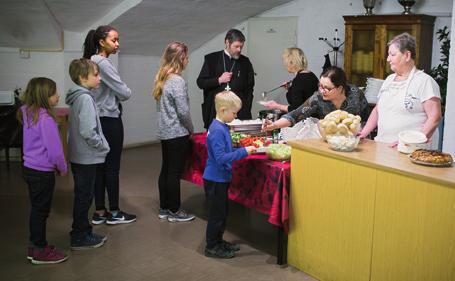 Ruokailun kohokohta: Isä Mikko Leistola jakaa koululaisille ylösnousemus-munia. yönä. Alttarin ovet pidetään koko viikon ajan auki ja papeilla on yllään valkoiset jumalanpalveluspuvut.