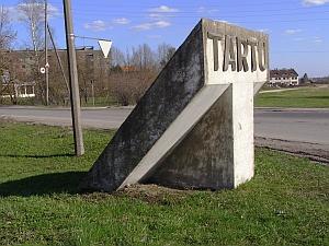 Tellisest väravahoone kunagise Tartu Asfaltbetooni tehase väravas. Avar varikatus toetub peenikestele metallpostidele.