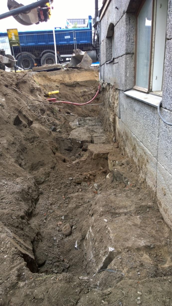 Noin kahden metrin syvyydessä tuli vastaan suuria, halkaisijaltaan noin 50-75 cm olevia kiviä hieman irrallaan seinästä. Kivien päällä oli savea ja sen päällä täyttömaata.