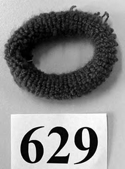 6117 80 10 Lenkin muotoinen sovitettu tavara, joka on tehty elastisesta pyöröneuloksesta (tekokuitua), johon on yhdistetty kumilankaa. (hiuslenkki) (ks. valokuva nro 629) (*).