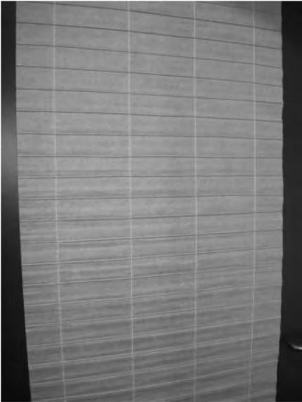 6303 92 10 Suorakaiteen muotoinen tavara, jonka mitat ovat noin 60 300 cm ja joka koostuu kahdesta yhteenliimatusta kerroksesta (joista toinen on tekstiilikangasta ja toinen paperia).
