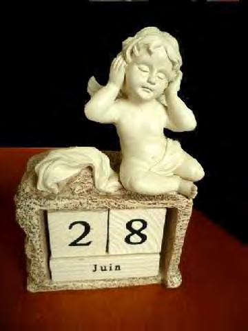 4910 00 00 Tavara, jossa on ikuinen kalenteri ja enkelin muotoinen muovinen pienoispatsas. Enkeli istuu muovisella jalustalla.
