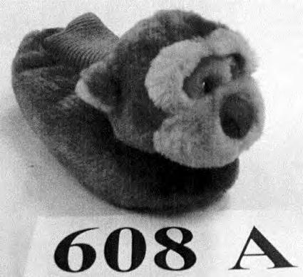 6405 20 91 Sisäjalkineet, joiden nukkaneulosta olevaan päälliseen on kiinnitetty nilkan peittävä joustinneulos ja etupäälliseen päällisen materiaalista tehty eläimen (apinan) pää.