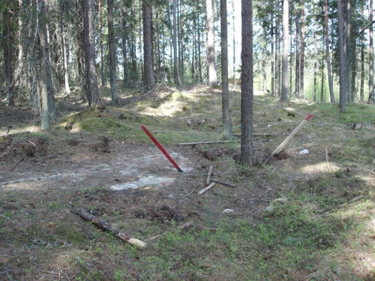 Säteilyturvakeskus URAKKA 18(42) Kuva 4. Kaksi syväkairausreikää talousmetsässä. Reiät on merkitty suojaputkiin asennetuin paaluin. Kalliopaljastumasta on otettu uranäyte timanttisahalla. Kuva: O.