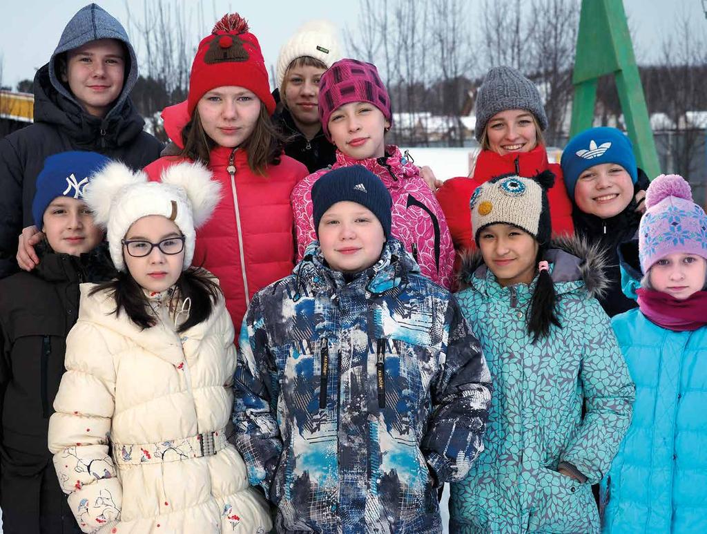 Lisa (keskellä) ja Lena (edessä oikealla) uusien veljiensä ja siskojensa kanssa Jekaterinburgin turvakodin pihalla. ja löysi mieluisan harrastuksen: hiihdon.