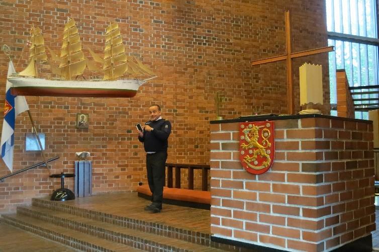 Pastori Henri Kivijärvi. Katosta riippuu suurin Suomen Joutsenesta tehty pienoismalli. Kajanuksen sauna Upinniemen kärjessä.