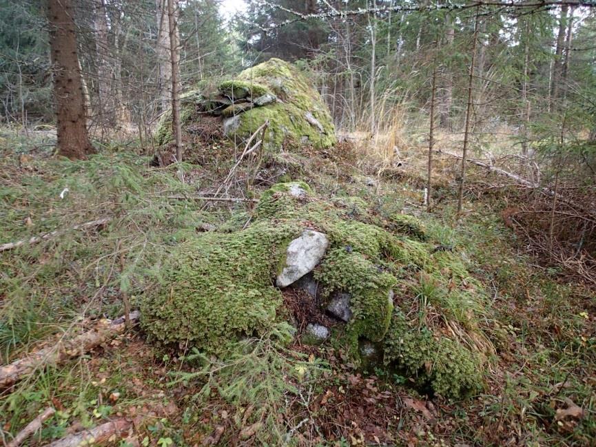 muinaisjäännökseksi. Läntisin röykkiö on tyypillinen pieni (karttalaukku mittakaavana) maapohjalla oleva röykkiö. Kuvattu itään.