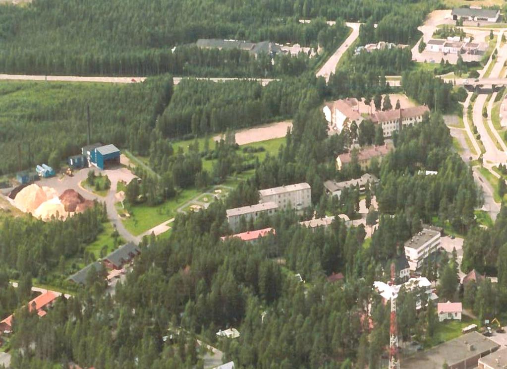 Nykyinen kaukolämpölaitos kuvan vasemmassa reunassa ja purettava jälleenrakennuskauden koulukeskus oikealla reunalla. Ilmakuva 2001.
